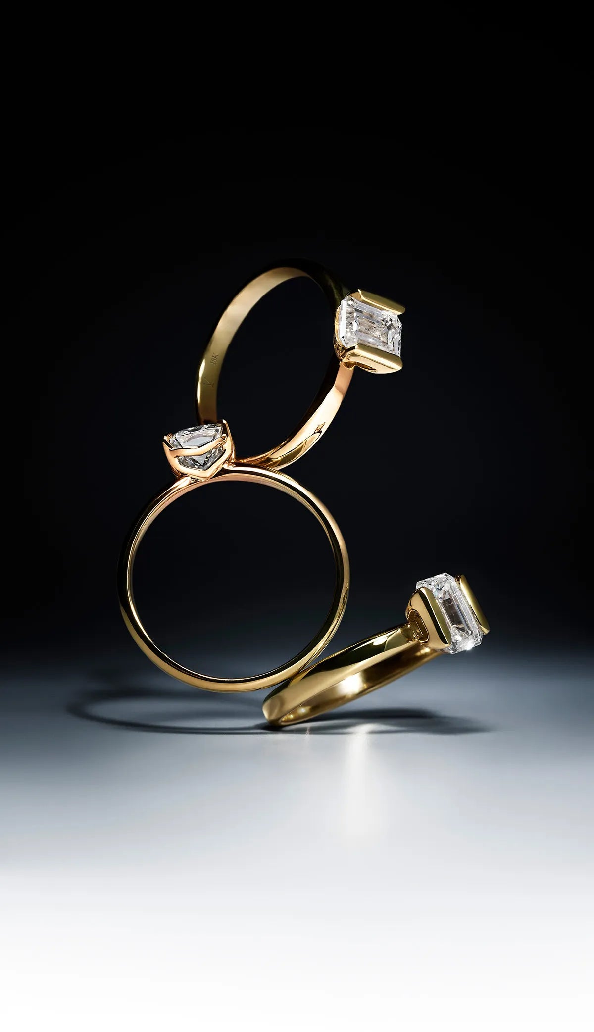 Three Delve Jewellery golden rings with lab-grown diamond accents on a dark background